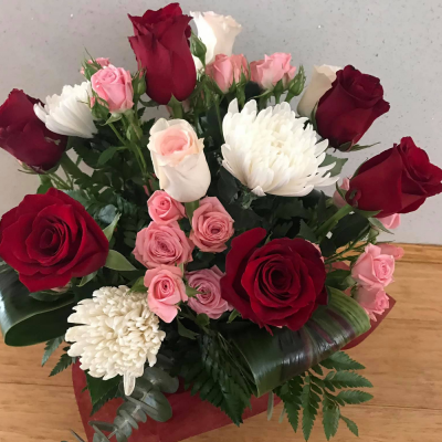 Make Them Wink - A stunning handtied in water presented in a gif bag/box. Created using white flowers accompanied with pale pink and red roses with complimentary foliage. Hand delivered with care in and around Perth by Carramar Flowers & Gifts.