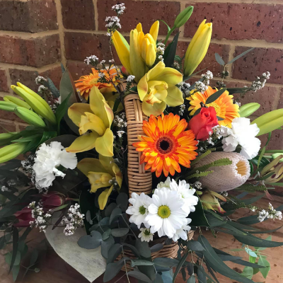 Feeling Tropical - A vibrant basket arrangement. Created using yellow, white and orange flowers with complimentary foliage. Hand delivered with care in and around Perth by Carramar Flowers & Gifts.